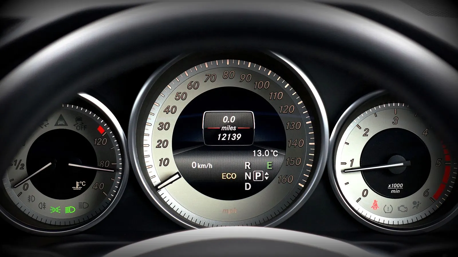 A car's instrument cluster with the speedometer in the middle and the coolant temperature gauge on the left, beside the speedometer